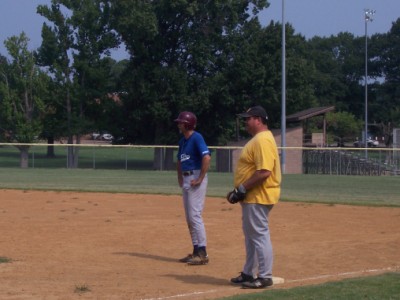 Bruce Monti stands on first after another hit, Papi tries to block the cameras view